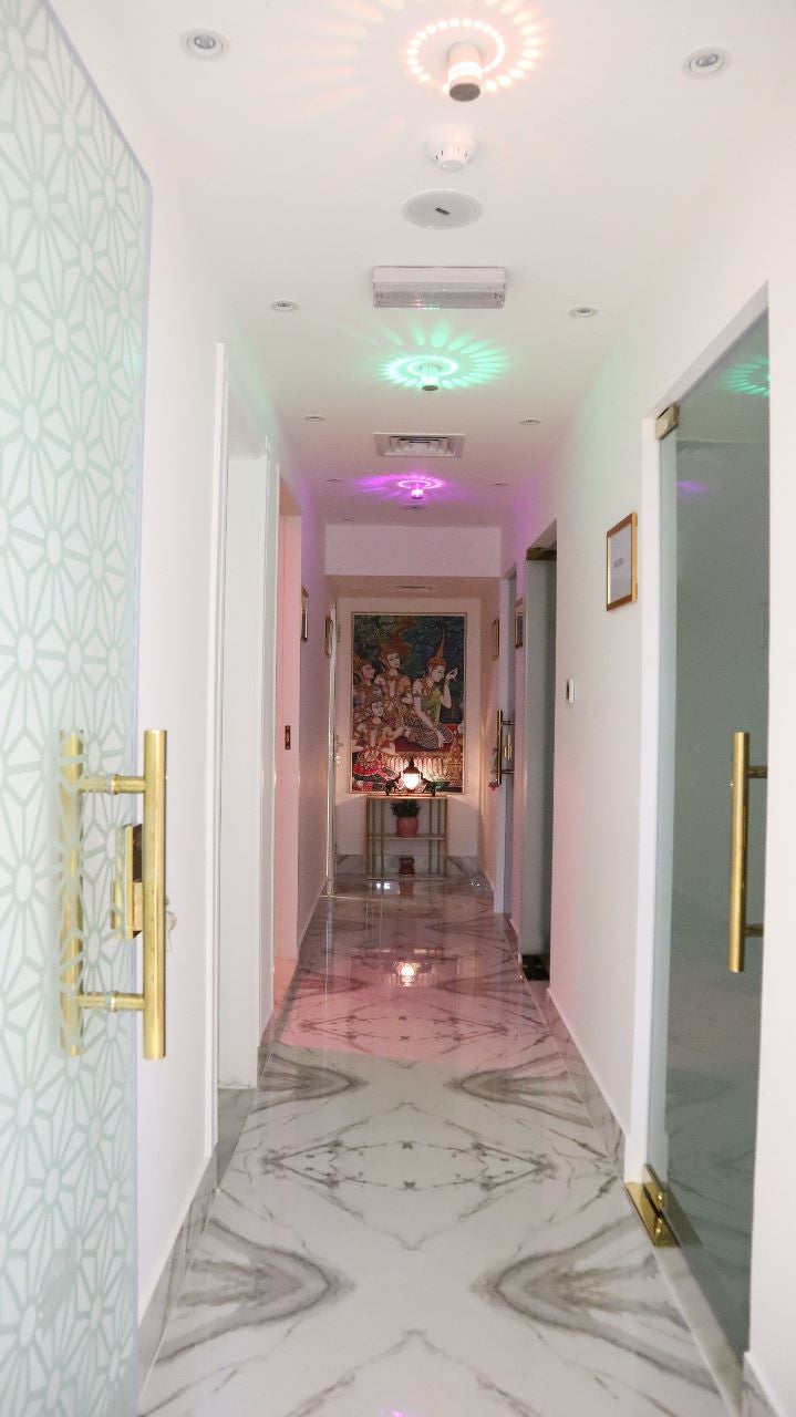 Corridor washed in soft coloured light between treatment rooms