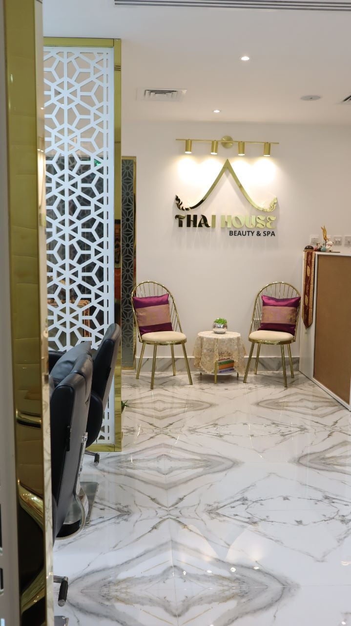 Seating beneath the Thai House logo wall, framed by carved wooden panels