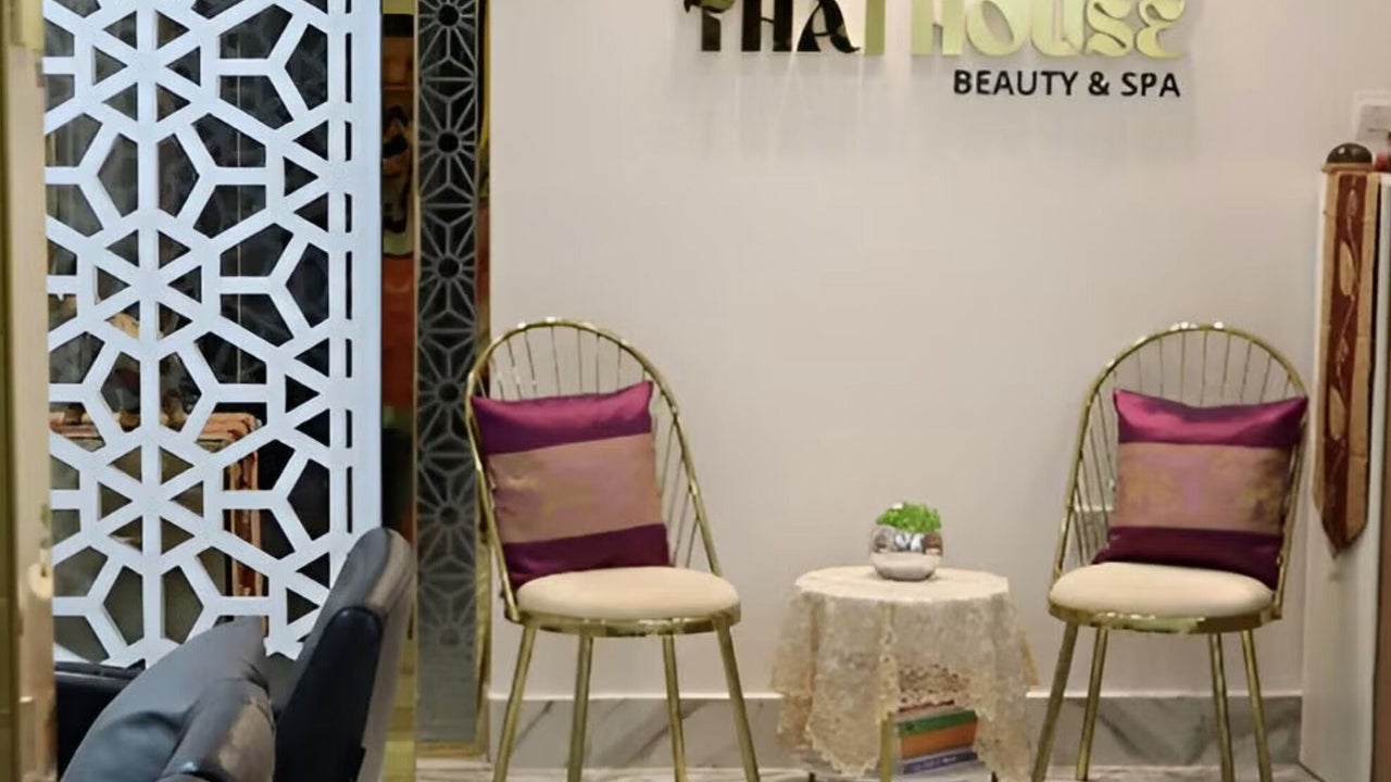 Seating area beneath the Thai House sign, with patterned cushions and marble floors