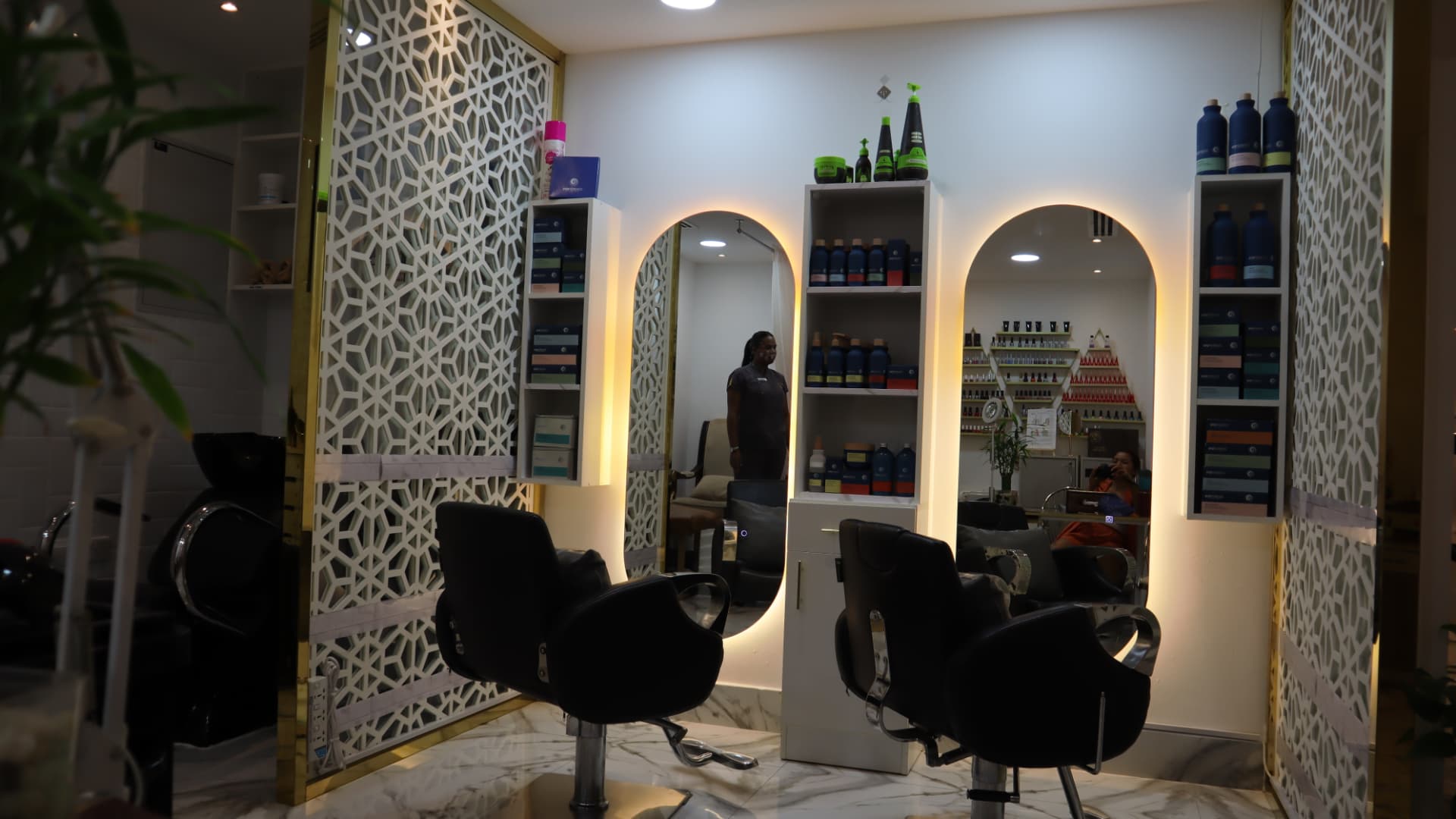 Salon area framed by white lattice screens with gold trim and marble flooring