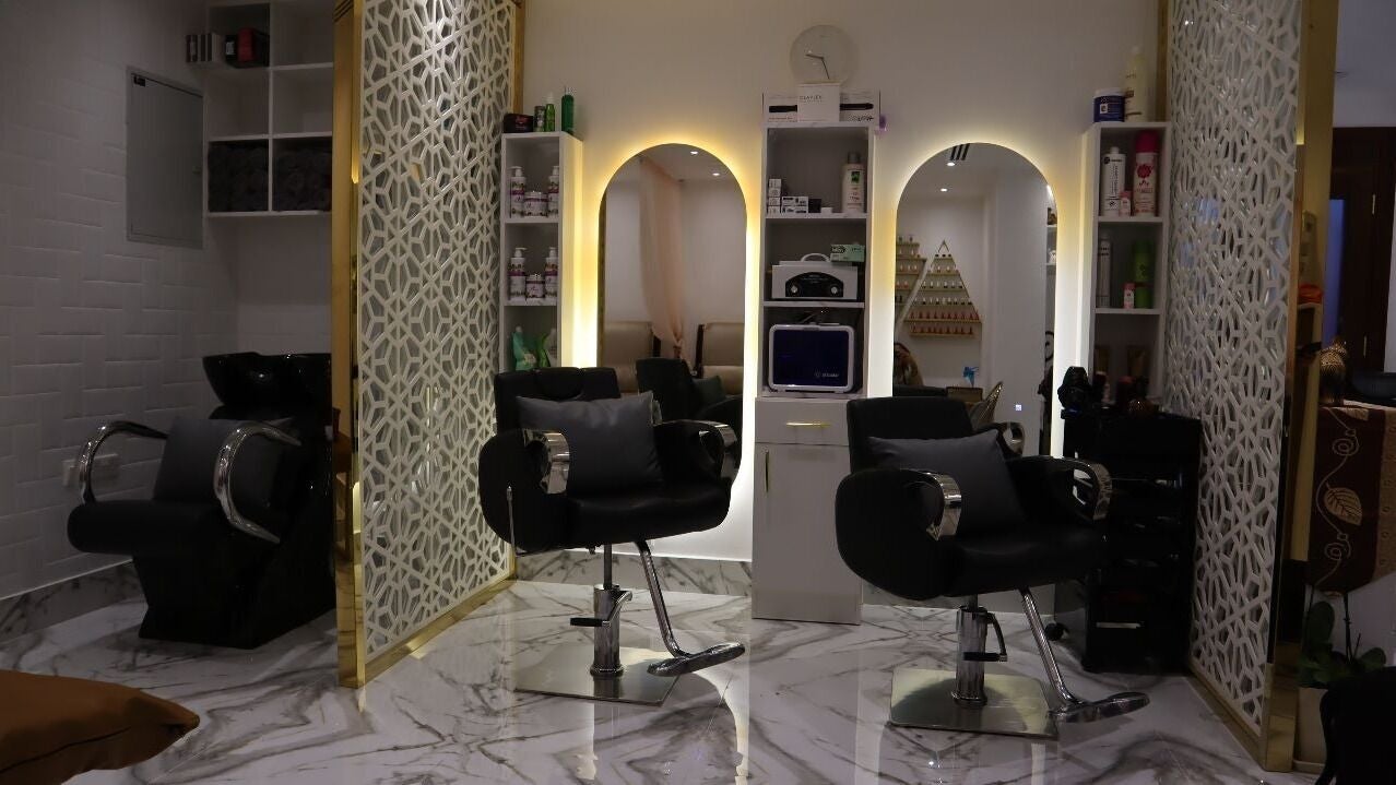 Styling chairs facing gold-trimmed mirrors in the salon